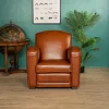 Fauteuil Club Grand Carré en cuir de basane havane, vue de face en ambiance élégante, assise profonde et lignes structurées.