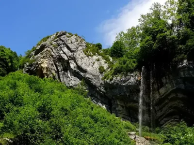 Formation rocheuse en forme de chapeau, affaissement, végétaux et cascade d'eau 