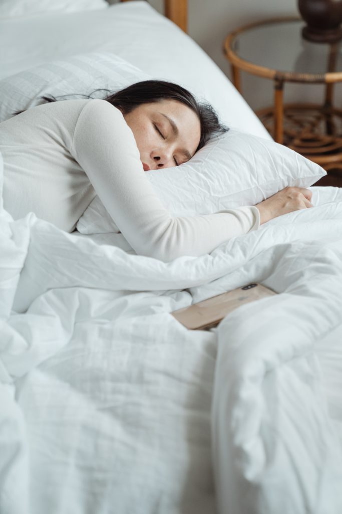 Une femme dort profondément sur son lit
