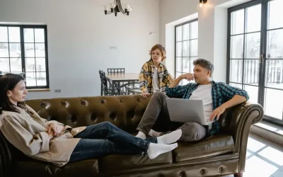 Une famille installée dans un canapé chesterfield en cuir vert