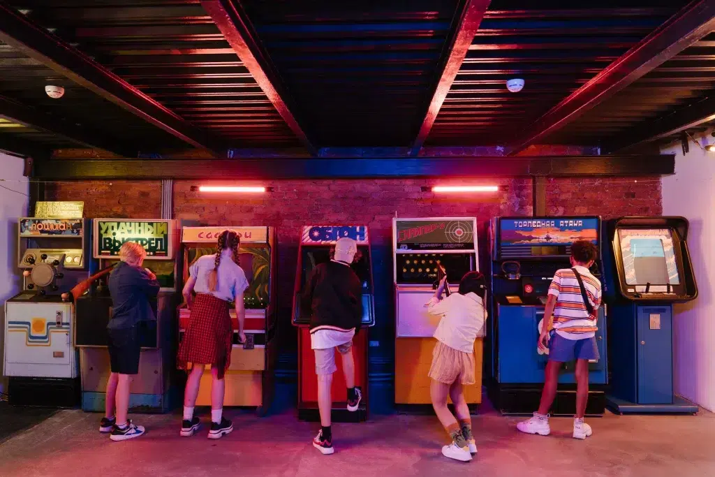 Enfants qui jouent à des bornes d'arcades ambiance années 80