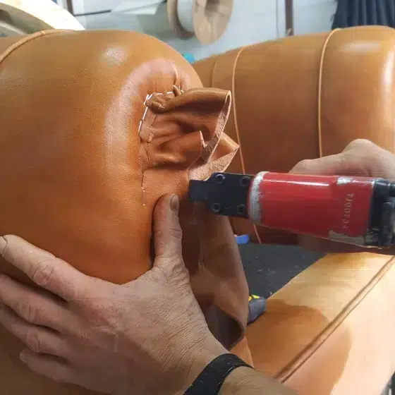 Étape de fabrication d'un fauteuil club, la pose du cuir de basane