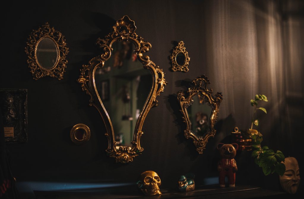 Plusieurs miroirs avec des cadres en moulure dorée accorchés sur un mur