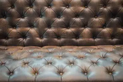 Gros plan sur capitons d'un canapé en cuir marron clair