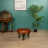 Repose-pieds Chesterfield rond en cuir Havane pleine fleur dans un salon élégant