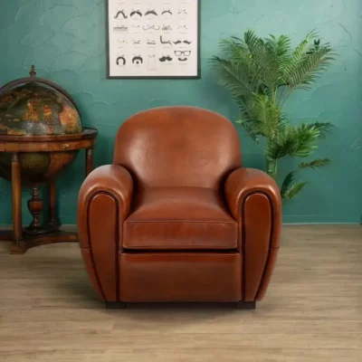 Fauteuil club Raymond en cuir de basane couleur havane, dossier rond et accoudoirs galbés, vue de face
